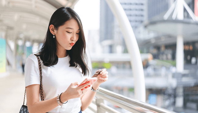 スマホとクレジットカードを持つ女性